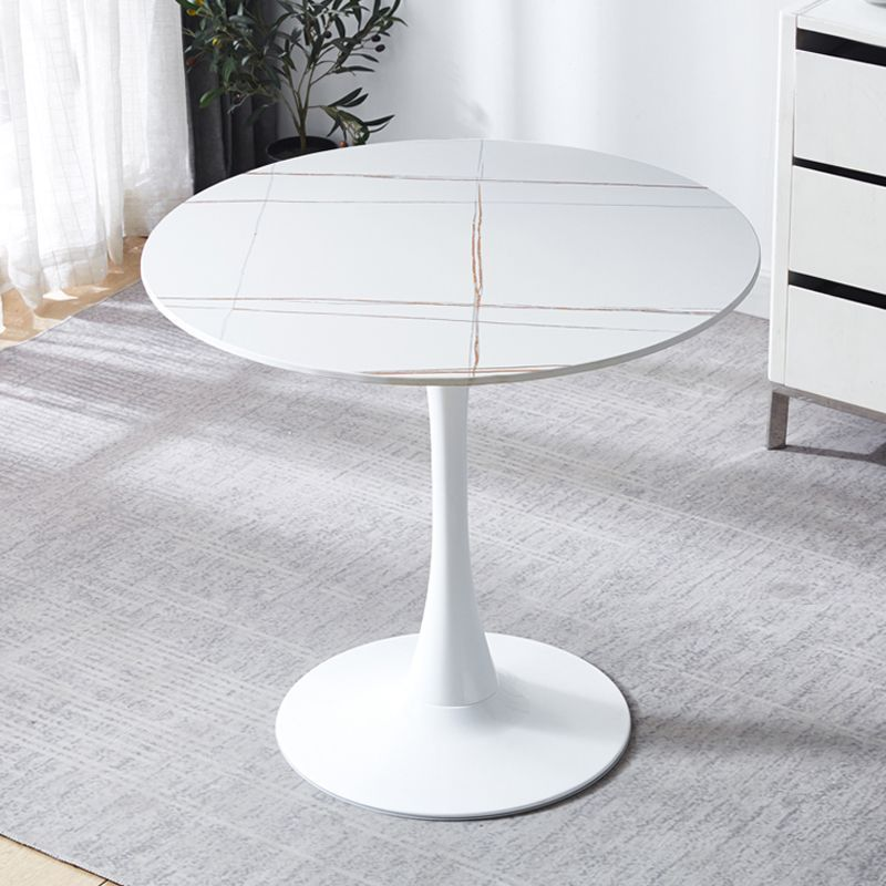 White round table in a room with light gray carpet and white curtains.